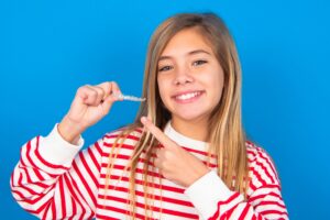 girl holding an aligner