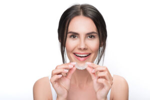 Woman holding set of clear aligners