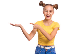 Teen girl smiling in yellow shirt on white background