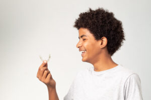 boy teenager afro smiling with dental aligners